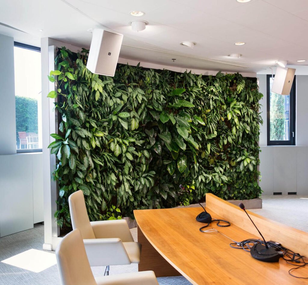 Een groene gevel siert de binnenkant van het kantoor, waarbij natuurlijke elementen worden geïntegreerd in de werkruimte