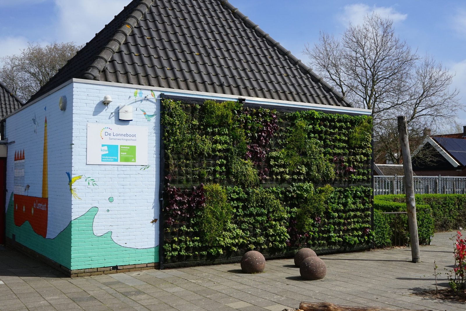 Een overzichtsfoto van de groene gevel aan de school: ''De Lonneboot''.